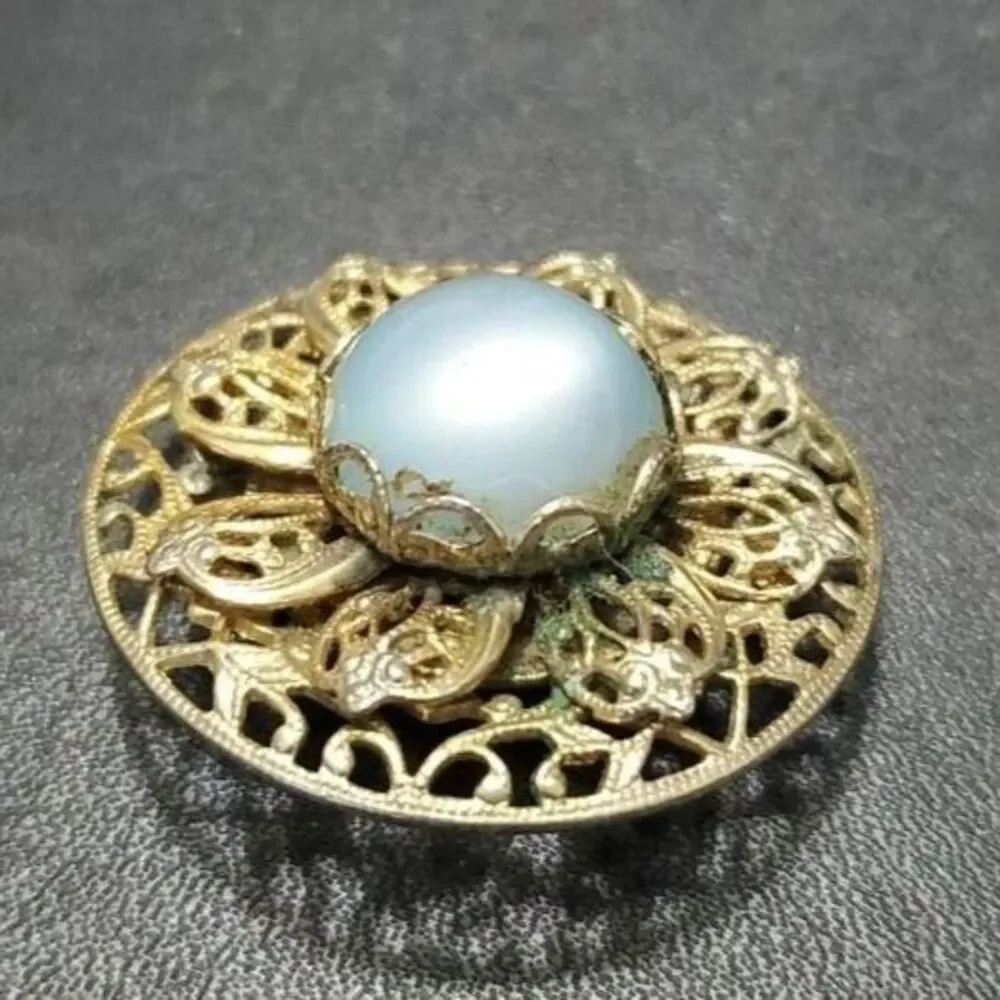 Vintage gold tone round brooch with blue